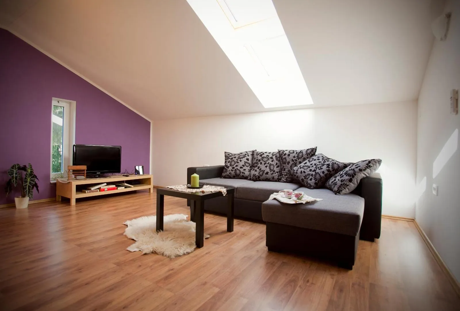 Apartma 55: dnevna soba pod strešnim oknom z velikim kotnim kavčem