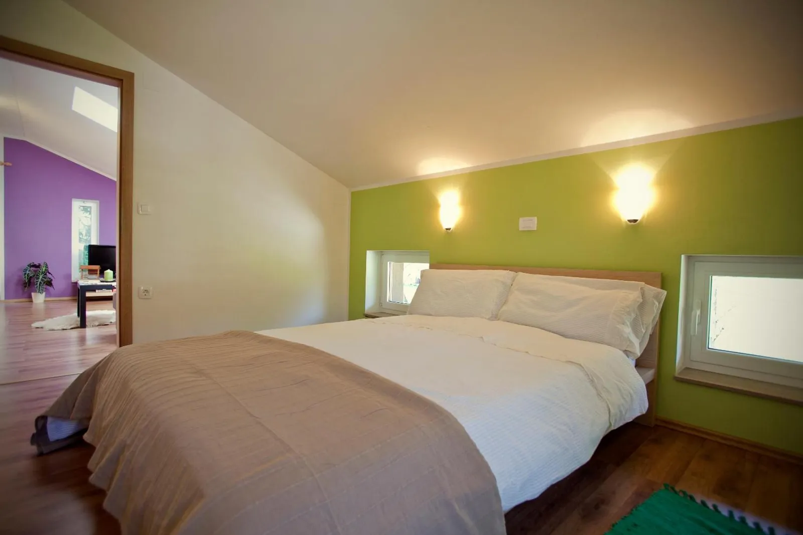 Apartma 55: spalnica z zeleno steno in dvema oknoma